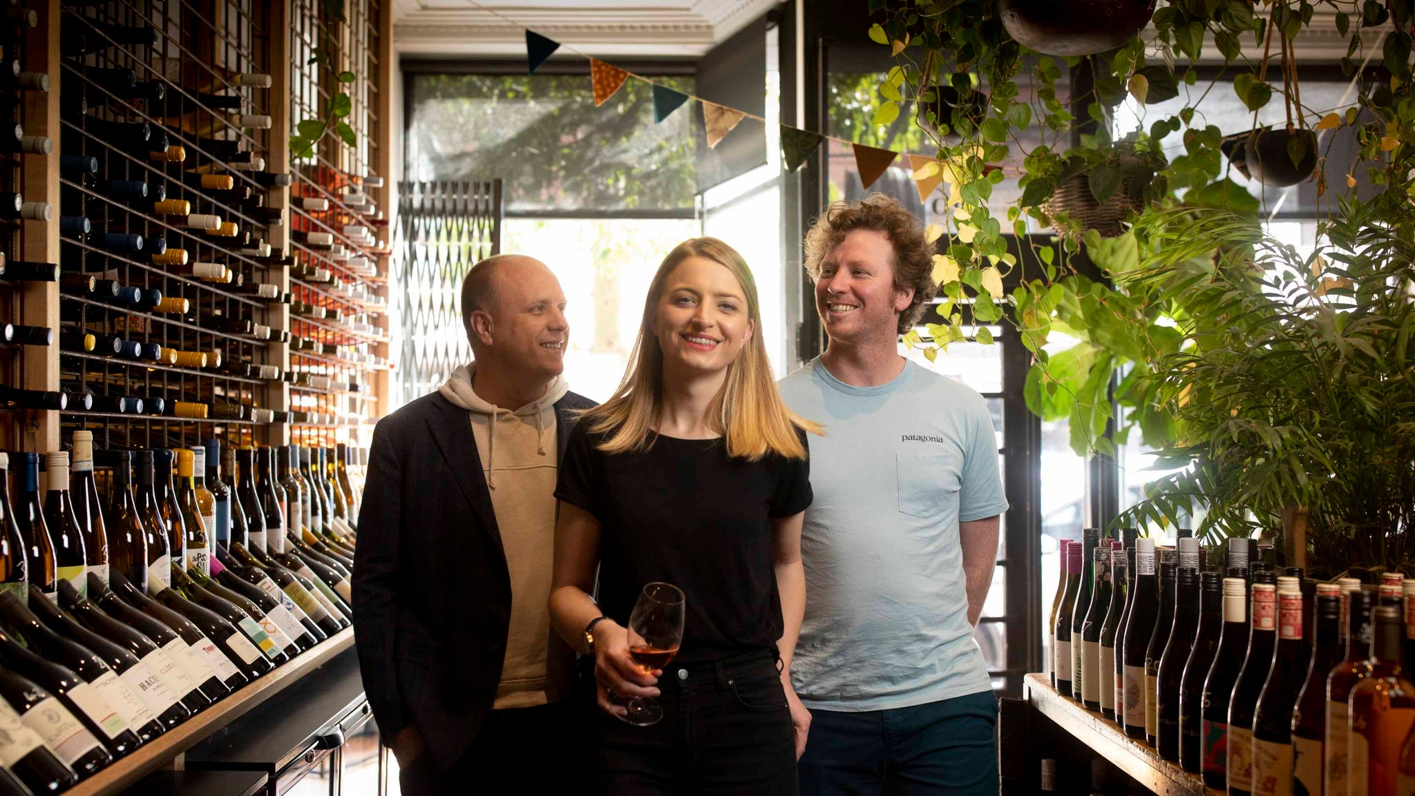 Image shows Hey Tomorrow partners Jesse Gerner, Sacha Imrie, Shane Barrett standing in Samuel Pepys Wine Merchant, Northcote, Melbourne, Australia